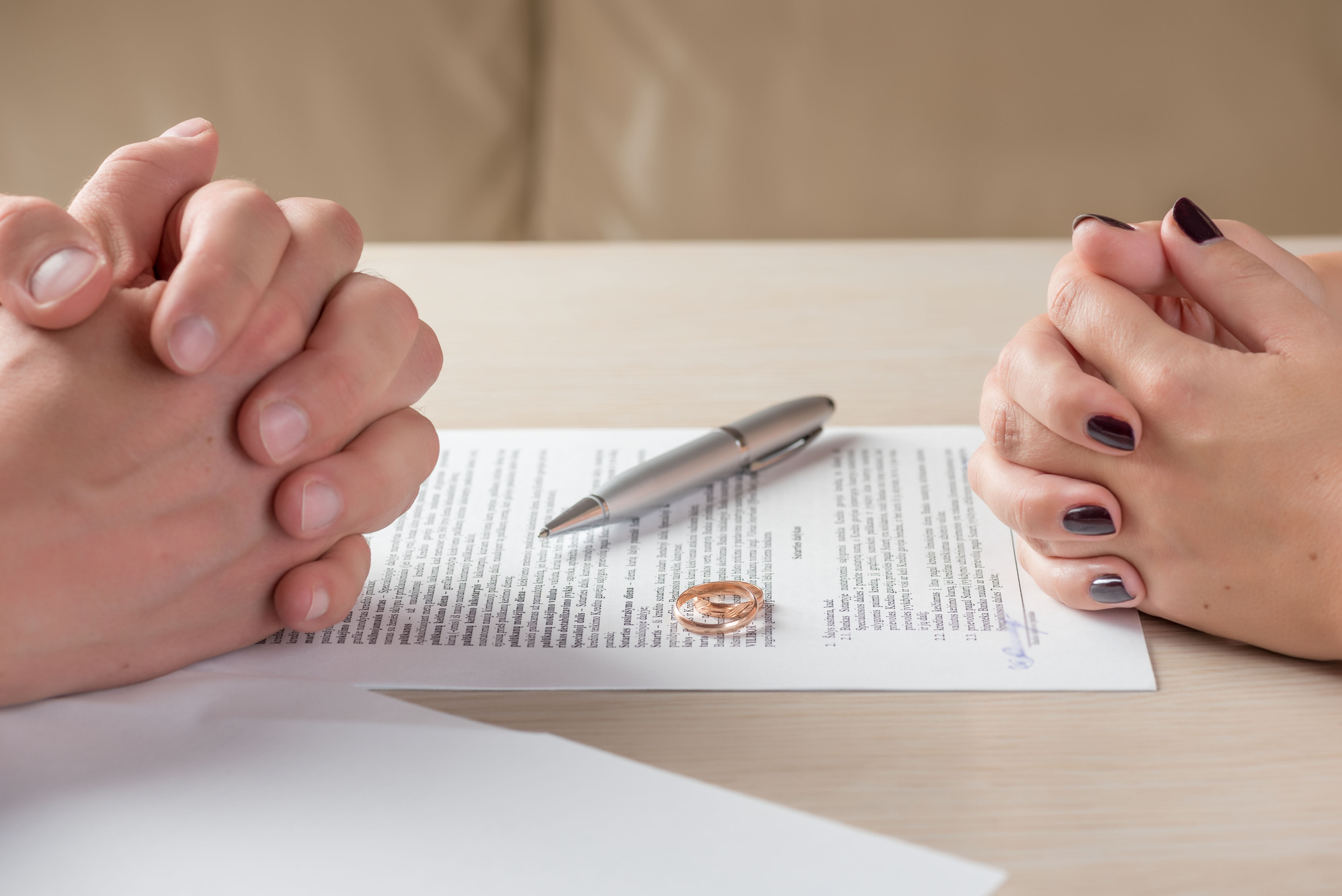 wife and husband signing divorce documents or premarital agreement