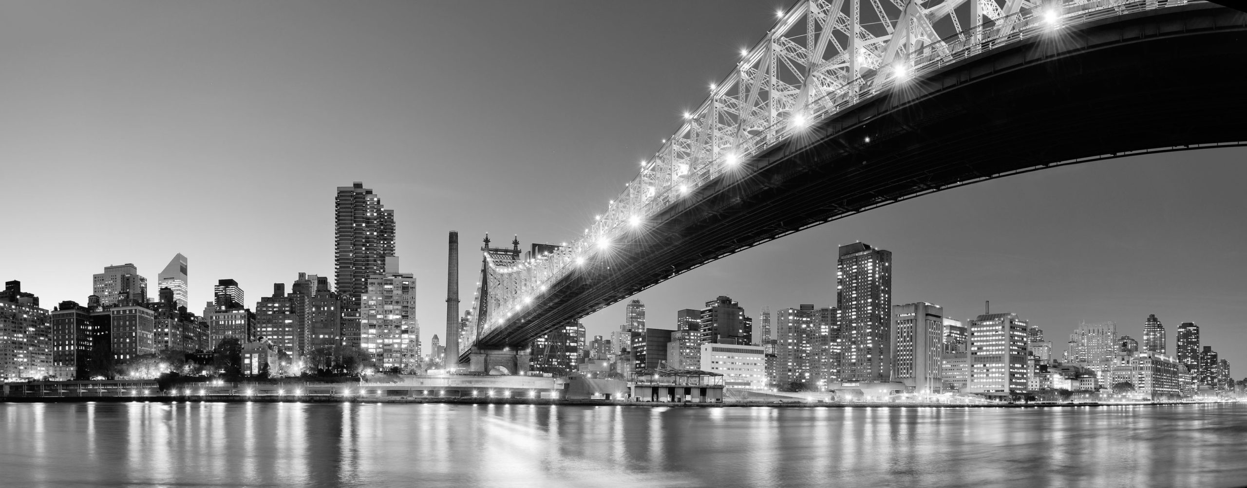 black and white New York City scene with bridge over river